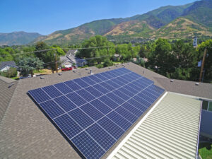 Solar panels on a home roof with mountains in the background.