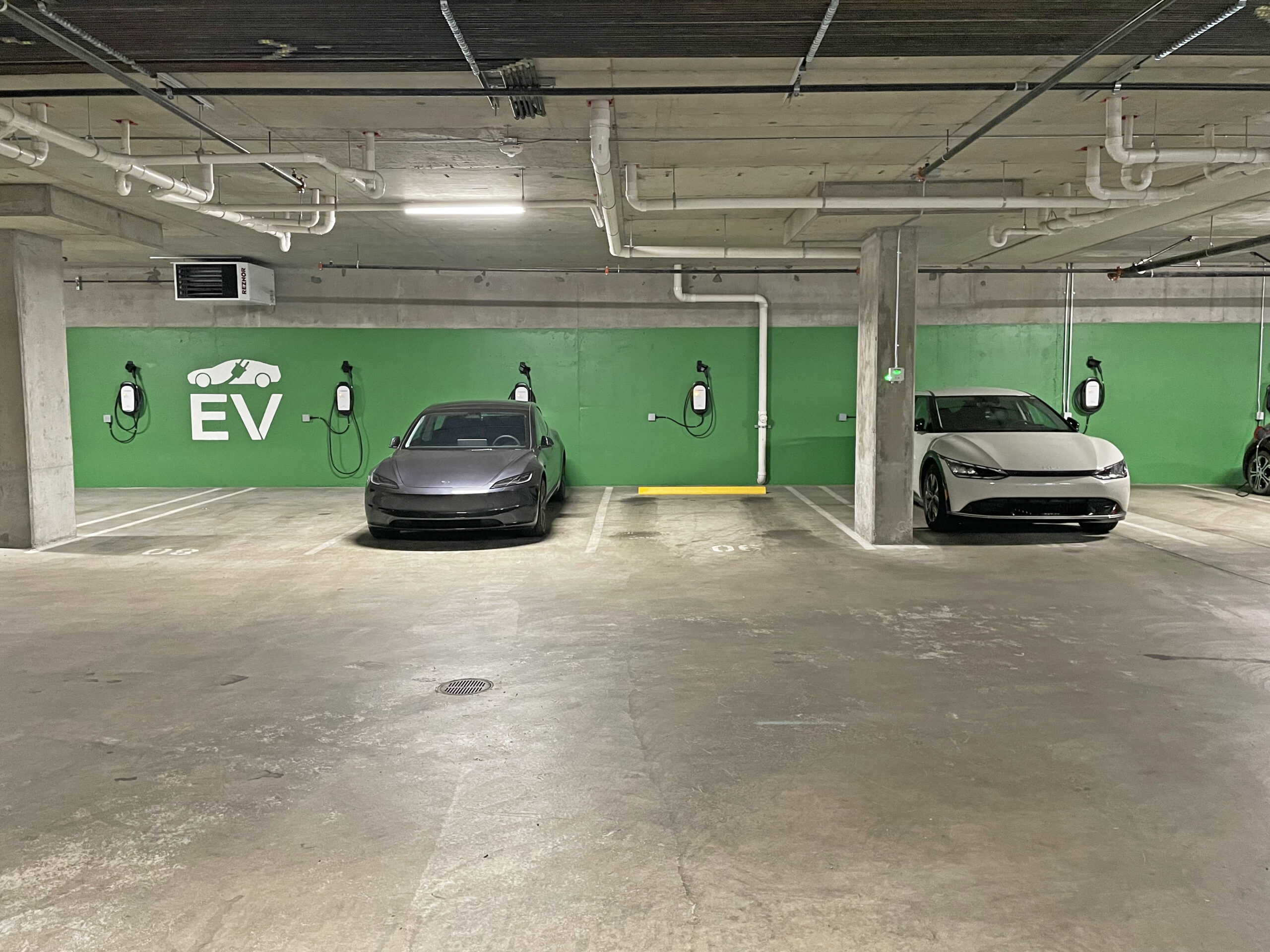 EV charging station installations are available for apartments to charge cars like the Tesla shown in this picture.