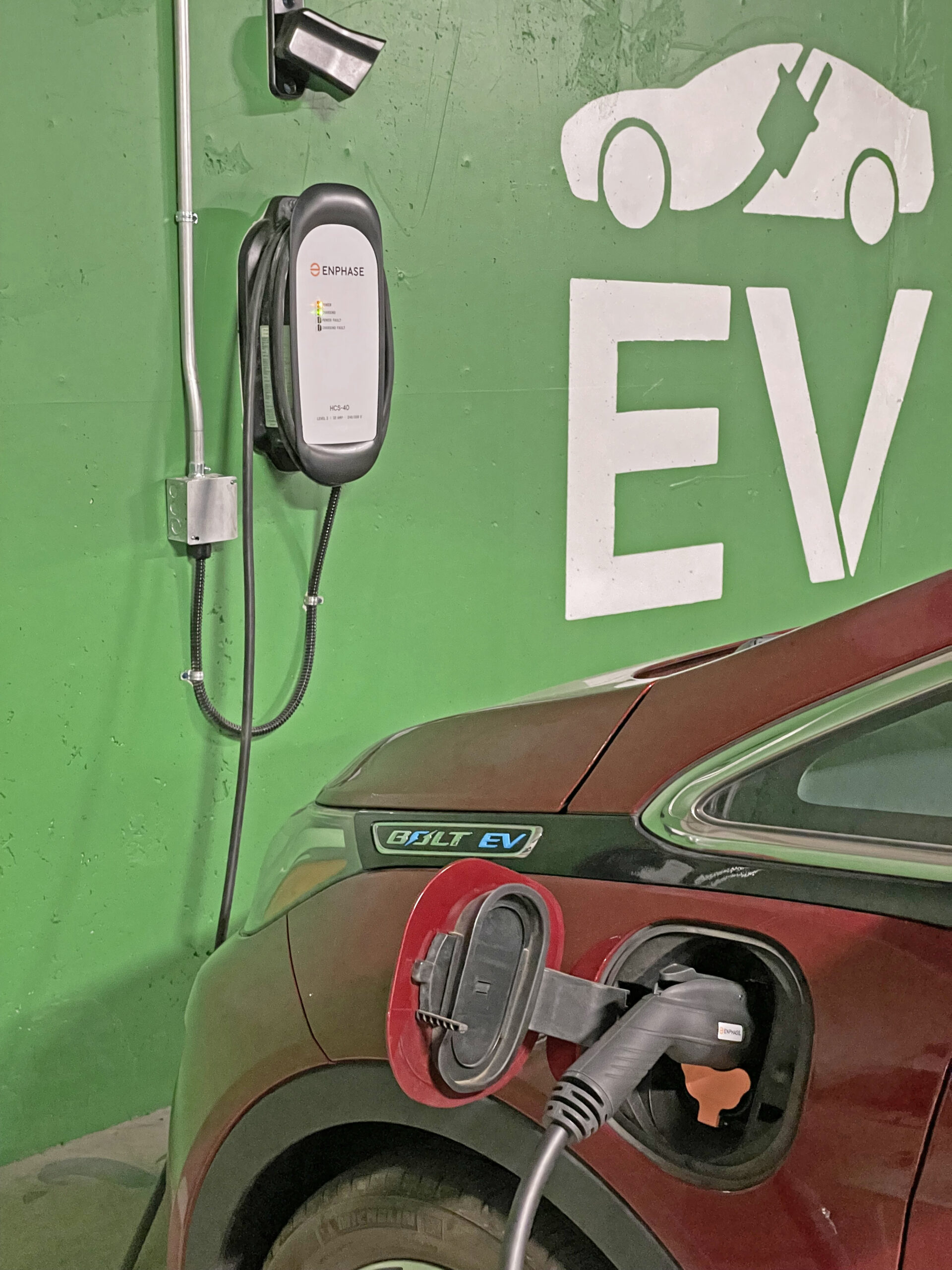 An EV charger Utah plug charging a red car.